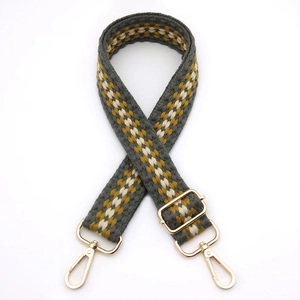 Detail of grey and yellow woven bag strap with adjustable golden metal buckles