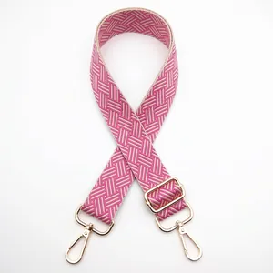 Detail of adjustable woven shoulder strap featuring pink and beige herringbone patterns