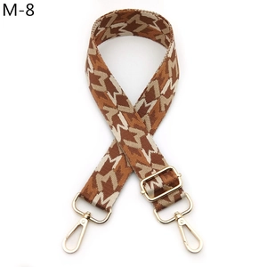 Detail of adjustable geometric jacquard shoulder strap with gold metal lobster clasps