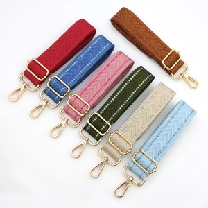 Detail of adjustable woven bag straps with colorful herringbone patterns and gold hardware