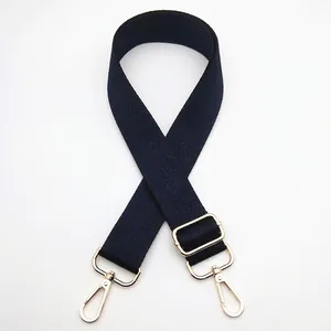 Detail of adjustable dark blue and black woven shoulder strap with gold metal lobster clasps