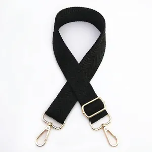 Detail view of adjustable black wide shoulder strap with golden metal lobster clasps