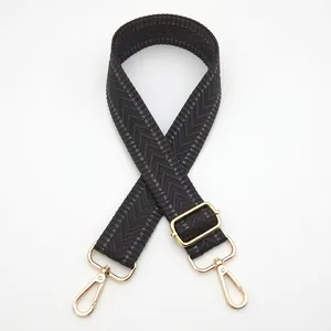 Detail of adjustable black and grey herringbone woven strap with golden metal hardware hooks