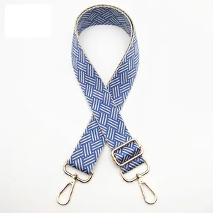 Detail of adjustable woven blue and beige strap with golden lobster metal clasps