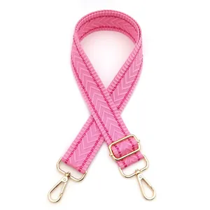Detail of adjustable pink woven shoulder strap with gold metal buckle and chevron pattern