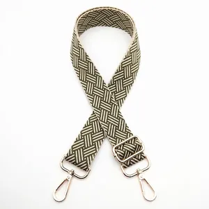Detail of army green and beige woven purse strap with gold metal buckle and slider