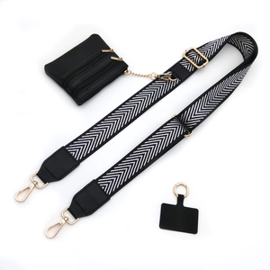Detail of adjustable black and white woven strap with golden hooks and small zipper pouch