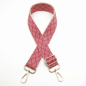 Detail showing red and white geometric woven strap with gold metal lobster clasps
