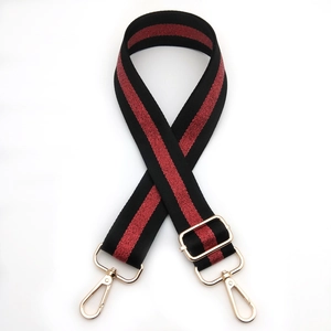 Detail of adjustable black and red woven bag strap with gold metal swivel hooks