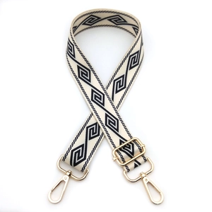 Detail of adjustable wide shoulder strap with navy geometric patterns and gold lobster clasps