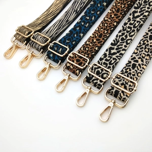 Detailed view of adjustable leopard print bag straps with golden metal lobster clasps