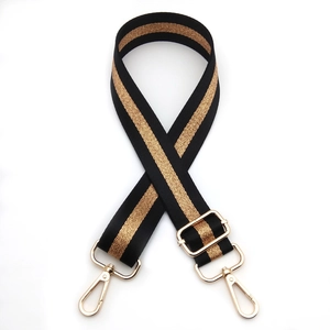 Detail of adjustable black and gold striped bag strap with shiny metal lobster clasps