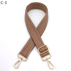 Detail of chevron woven bag strap with golden rotating metal hooks and slide adjuster