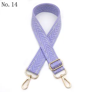 Detail of lavender woven shoulder strap with silver herringbone pattern and gold metal hooks