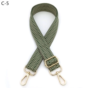 Close-up of adjustable woven shoulder strap with green chevron pattern and gold hardware
