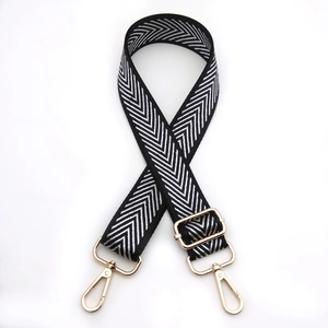 Close-up of arrow pattern woven bag strap with adjustable light gold metal buckles