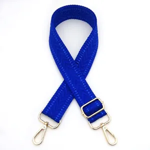 Detail view of dark blue chevron woven bag strap with golden metal swivel hooks