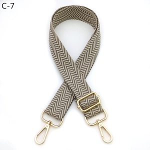 Detail of adjustable gray and beige wave pattern strap with gold metal lobster buckles