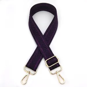 Close-up of purple woven shoulder strap with gold metal hooks and adjustable buckle