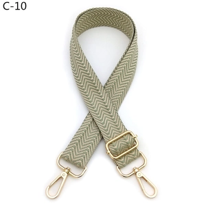 Detail showing green chevron patterned shoulder strap with gold metal hooks and buckle