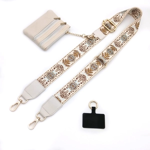 Detail of bohemian floral embroidered bag strap with gold buckle and mini zipper pouch