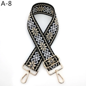 Détail d'une bandoulière ethnique en jacquard avec motifs et mousquetons en métal doré