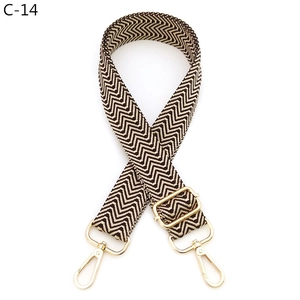 Detail of coffee and beige wave pattern woven bag strap with gold metal buckle
