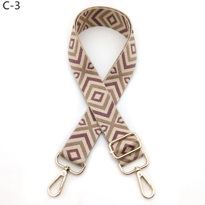 Detail of adjustable geometric diamond pattern bag strap with gold lobster clasps