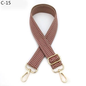 Macro detail of red and white chevron woven strap with adjustable gold lobster clasp