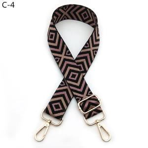 Detail of adjustable geometric woven shoulder strap with gold metal hooks and buckle