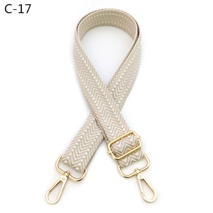 Detail of beige herringbone woven strap with shiny gold adjustable metal hooks