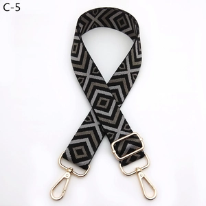 Close-up of geometric diamond weave bag strap with gold metal lobster buckles