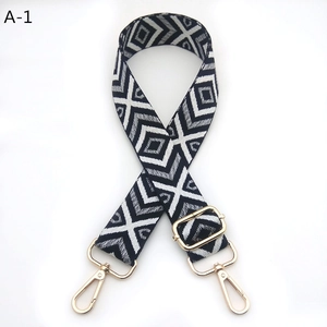 Detail of adjustable geometric diamond pattern bag strap with gold metal lobster clasps