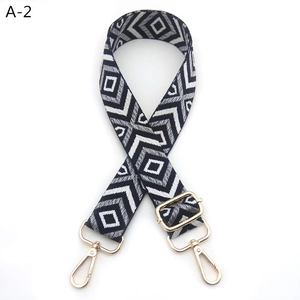 Close-up of diamond pattern woven shoulder strap with gold adjustable metal hardware