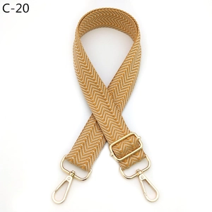Detail view of yellow and white chevron pattern bag strap with gold metal hardware