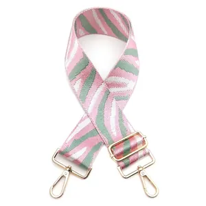 Adjustable woven shoulder strap with pink and green zebra pattern and gold lobster clips