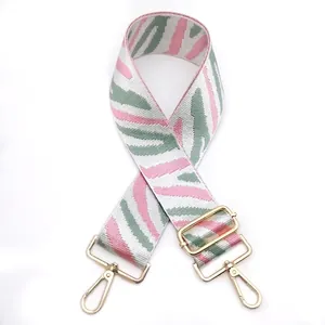 Detail of zebra pattern wide bag strap with golden metal swivel hooks and adjuster buckle
