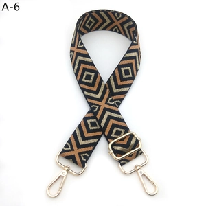 Detail of adjustable geometric diamond pattern bag strap with gold metal lobster clasps