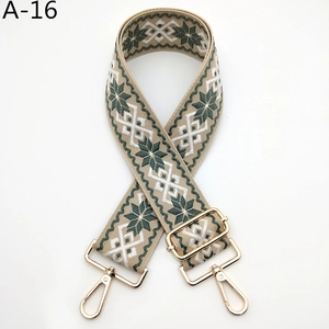 Détail d'une bandoulière jacquard réglable avec crochets métalliques dorés