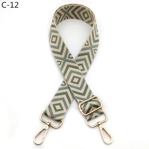 Close-up of adjustable woven bag strap with green and beige geometric diamond patterns