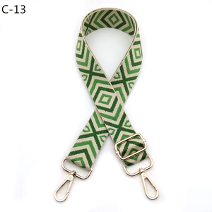 Close-up of green and beige diamond woven shoulder strap with gold metal buckles