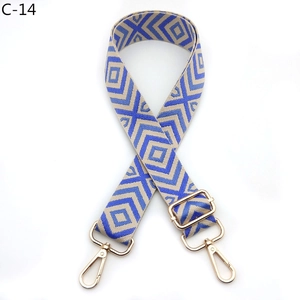 Detail of adjustable blue and beige geometric pattern bag strap with gold metal hooks