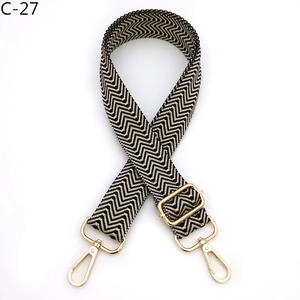Detail of adjustable black and white chevron bag strap with gold metal lobster hooks