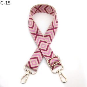 Detail view of pink and wine red geometric diamond pattern adjustable bag strap with gold hooks