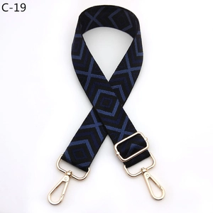 Detail of adjustable woven bag strap with blue geometric diamond pattern and gold hardware