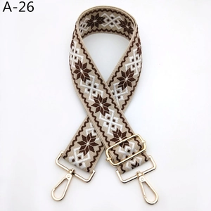 Détail d'une bandoulière ethnique réglable avec crochets dorés et motif géométrique de flocons