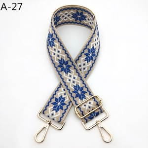 Détail de la sangle à motif flocon bleu avec mousquetons et boucle dorés