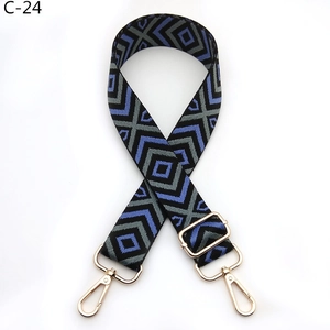 Close-up of adjustable woven strap with navy diamond pattern and gold metal hooks