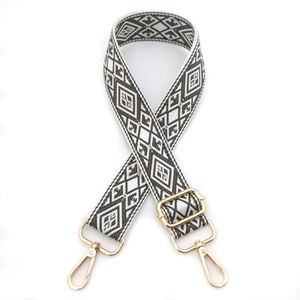 Close-up of adjustable woven shoulder strap with green diamond pattern and gold metal hardware