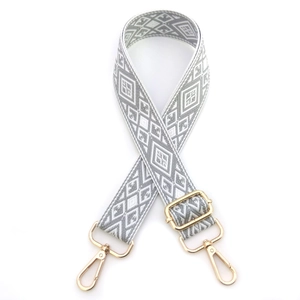 Macro detail of geometric diamond pattern woven bag strap with golden zinc alloy lobster clasps